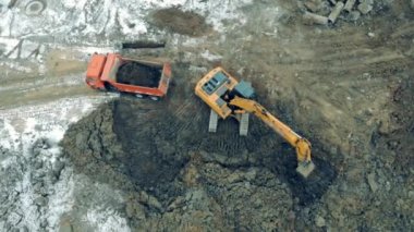 Industrial excavator working at a construction site. Tractor digs earth and loads a truck.