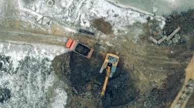 Industrial machinery working at a construction site. Many tractors move sand and earth while working at a career.