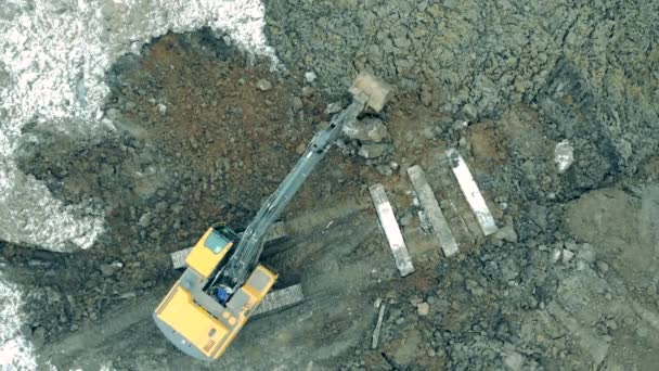 Construction excavator work at the industrial quarry. A tractor with bucket moves stones. — Wideo stockowe