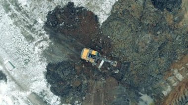 Machine moves stones with a bucket at a quarry.