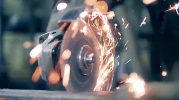 Moedor de ângulo de corte de metal em uma fábrica. Muitas faíscas de moagem . — Vídeo de Stock