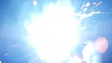 Welding sparks, slow motion. A worker uses a welding machine.