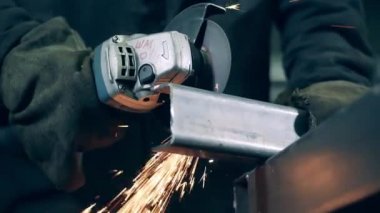 Grinding machine cuts metal at a factory. Metal cutting process wirh lots of grinding sparks.
