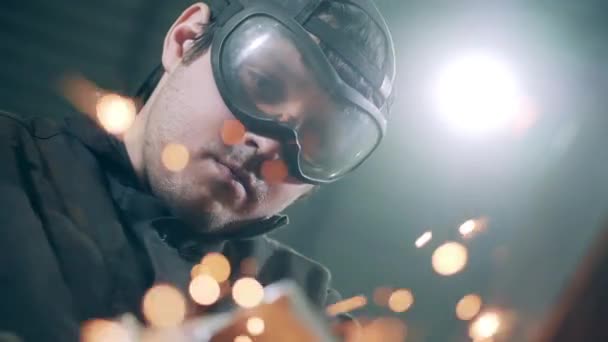 Metal cutting process wirh lots of grinding sparks. Man in uniform uses grinder at a plant. — Stock videók