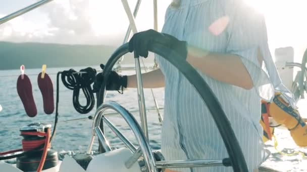 Eine Frau sitzt am Steuer einer Jacht. Frau auf einem Segelboot, Jacht während Sommerreise. — Stockvideo