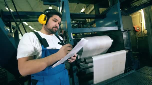 Unidad de fábrica de impresión con un ingeniero observando el proceso de trabajo — Vídeos de Stock