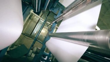 Beyaz kağıt bir baskı makinesi tarafından taşınıyor..