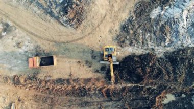 Taş ocağı boyunca hareket eden kazı makinelerinin üst görüntüsü. İnşaat, inşaat süreci.