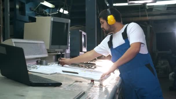 Trabajador de tipografía está editando un diseño en una unidad de fábrica — Vídeo de stock