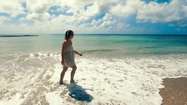 Dame sans soucis marche le long du rivage à marée basse — Video