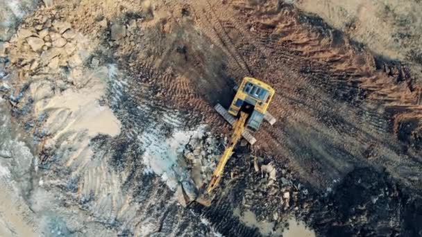 Vue de dessus d'une fosse d'emprunt avec une excavatrice creusant un terrain. Équipement industriel lourd de travail . — Video