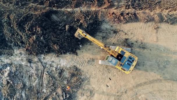 Bulldozer est en train de pelleter le sol dans une vue de dessus. Équipement industriel lourd de travail . — Video