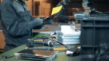 İnsanlar çöpleri bir tesiste geri dönüşüme hazırlıyorlar..