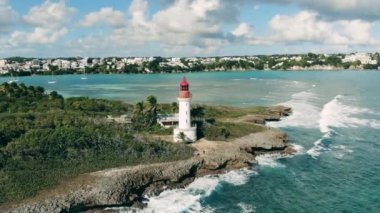 Deniz feneri bir tatil köyünün yanında.