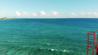 Turkuaz deniz suları ve deniz fenerinin üst kısmı.