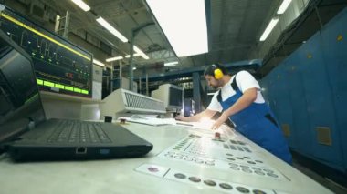 Erkek mühendis kontrol paneliyle çalışıyor.