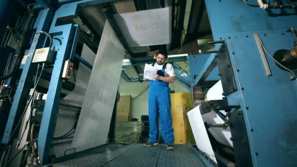 Engenheiro masculino está inspecionando equipamentos em uma unidade de fábrica de papel — Vídeo de Stock