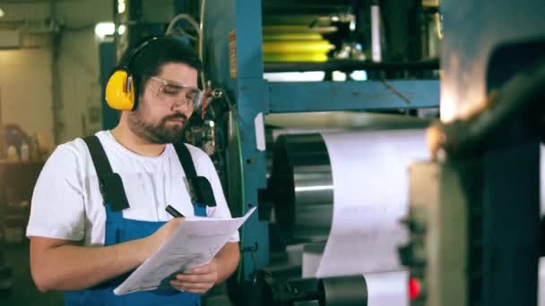Специалист по типографии наблюдает за рабочим процессом. инженер, рабочий на заводе . — стоковое видео