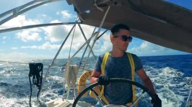 Dümenci denizde bir tekne kullanıyor.