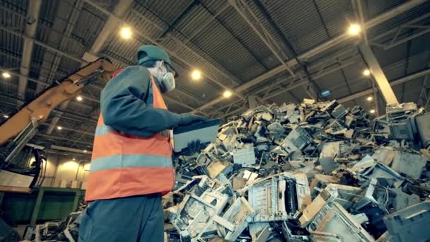 Basura, basura, fábrica de reciclaje de residuos. Hombre trabajador está observando una pila de basura en el interior — Vídeo de stock