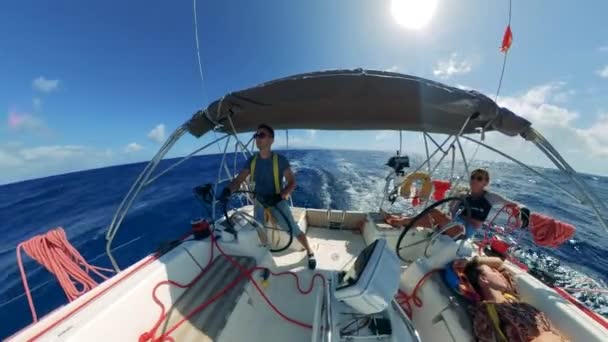 Amigos em um barco à vela durante as férias de verão, aventura marítima. Vista frontal de um navio sendo conduzido através do mar por um homem — Vídeo de Stock