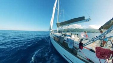 Sailboat with two ladies is sailing towards the coastline