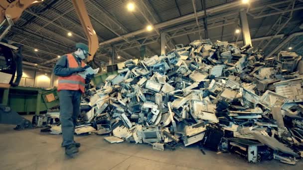 Fracciones de máquinas de oficina está siendo inspeccionado por un trabajador masculino. Basura, basura, fábrica de reciclaje de residuos . — Vídeo de stock