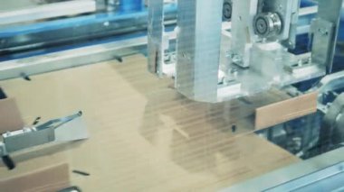 Factory machine is making cardboard boxes