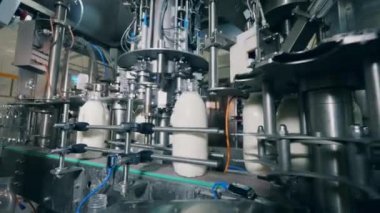 Etrafında cam süt şişeleri olan fabrika taşıyıcısı.