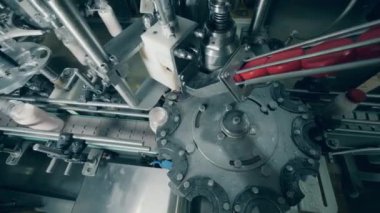 Fabrika mekanizması şişeleri yoğurtla işliyor ve paketliyor