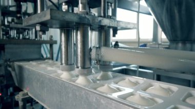 Taşıyıcıdaki beyaz süt maddesi konteynırları dolduruyor.