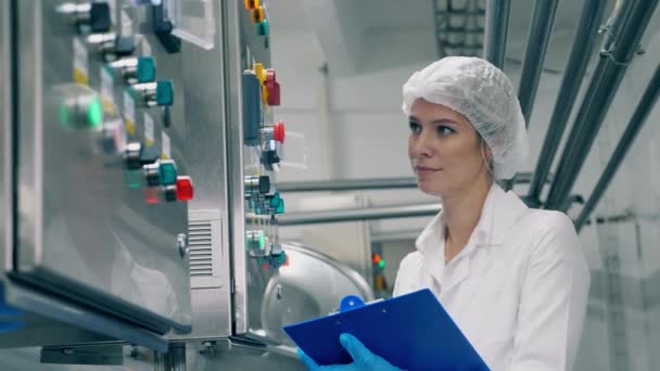 Lady expert está observando máquinas de fábrica com um sorriso — Vídeo de Stock