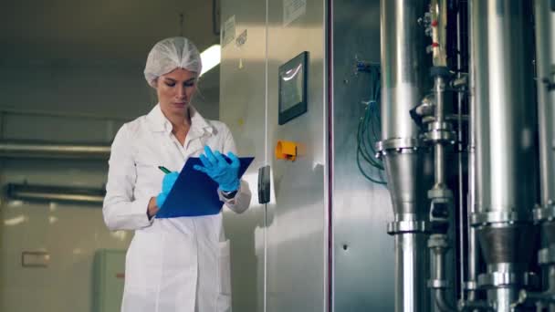 Lady expert is het bedienen van fabrieksuitrusting via een bedieningspaneel — Stockvideo