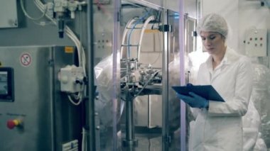 Kadın uzmanlar fabrika mekanizmalarını inceliyor.