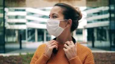 Tıbbi maskeli bir kadın etrafa bakıyor. Koronavirüs, salgın, salgın konsepti.