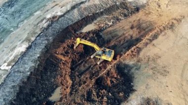 Sarı kazıcı taş ocağında çalışırken toprak taşıyor. Endüstriyel inşaat alanında ağır makineler.
