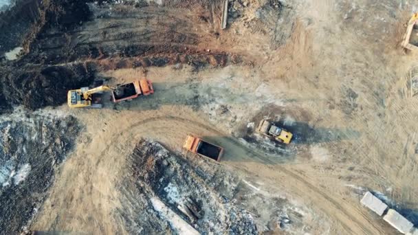掘削機はキャリアで砂でトラックを埋めます。建設機械、重工業機械. — ストック動画