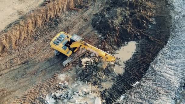 A máquina de trabalho escava a terra em uma carreira. Equipamento de construção, maquinaria da indústria pesada . — Vídeo de Stock