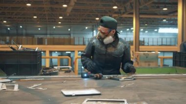 Endüstri işçisi bir dizüstü bilgisayarı söküyor.