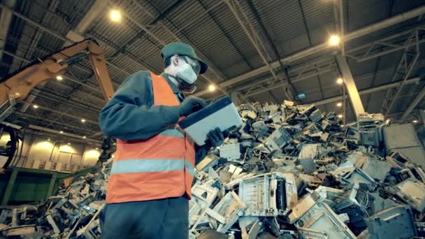 Erkek çalışan bir yığın bozuk elektronik eşyayı inceliyor. — Stok video