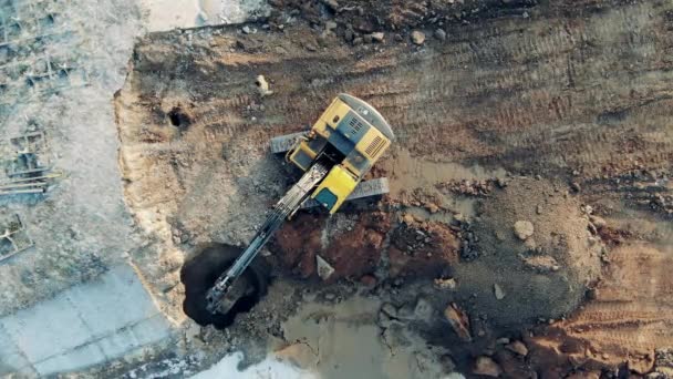 Een machine graaft zand tijdens het werken aan een grote carrière. Bouwmachines, machines voor de zware industrie. — Stockvideo