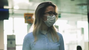 Tıbbi maskeli ve gözlüklü bir kadın camın arkasından filme alınır. Koronavirüs, salgın, enfeksiyon konsepti.