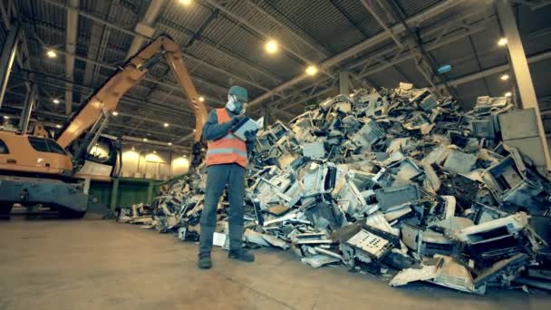 El trabajador de vertederos está observando una pila de máquinas de oficina rotas. Industria del reciclaje, fábrica de reciclaje electrónico usado . — Vídeo de stock