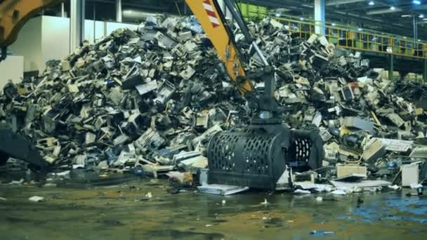 Çöp, plastik geri dönüşüm fabrikası. Kazıcı çöpü alıp yığının içine koyuyor. — Stok video