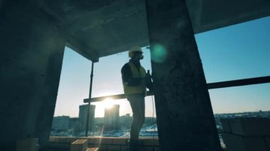 İnşaat işçisi beton bir sütunu cilalıyor.