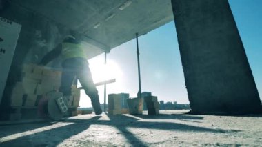 Erkek işçi inşaat halindeki bir binaya tuğla yerleştiriyor.