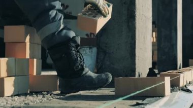 İnşaat işçisi tuğlaları diziyor.