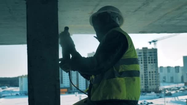 Construtor de construção masculino é polir uma parede de concreto — Vídeo de Stock