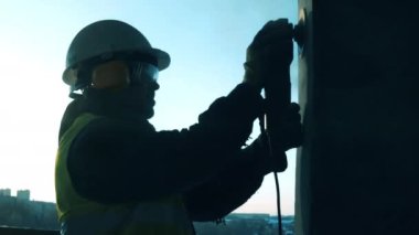 Çimento duvarı cilalayan bir erkek inşaatçının yan görüntüsü