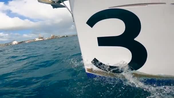 Vit båt med nummer tre på den flyter i havet — Stockvideo